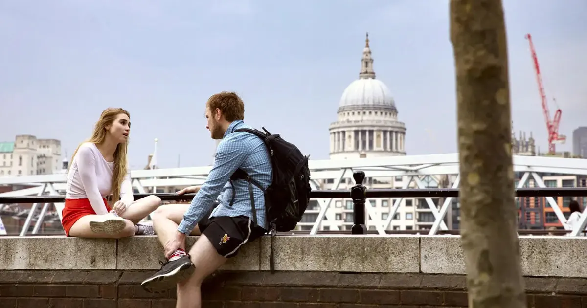 Two people having a conversation on a bridge