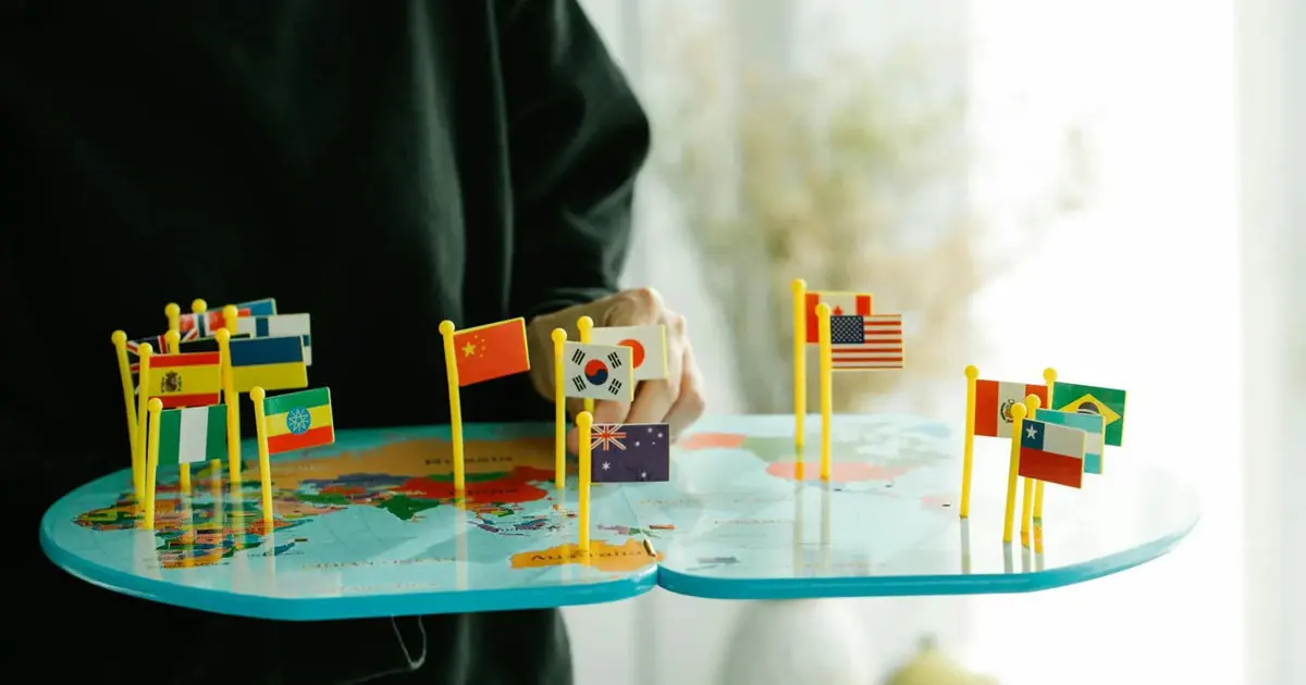 Man holding a glass map of the world with country flags